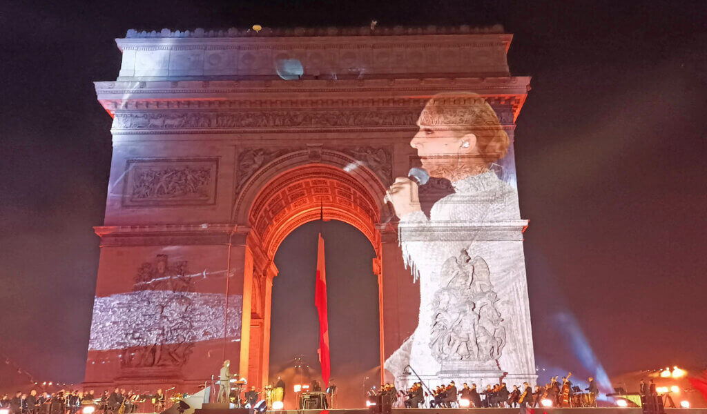 Wizerunek Céline Dion wyświetlany na Łuku Triumfalnym w Paryżu podczas wydarzeń Paris 2024