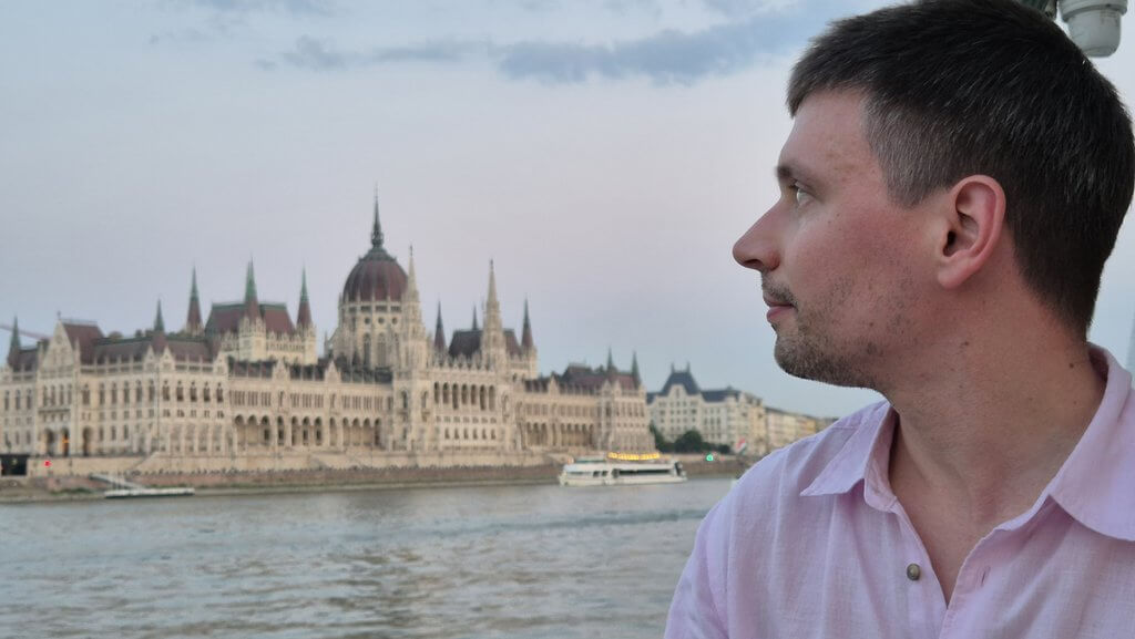 Łukasz Ptak nad Dunajem z budynkiem parlamentu w Budapeszcie w tle