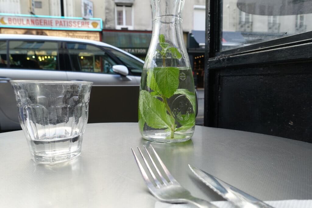 Karafka i szklanka wody na stoliku w restauracji w Paryżu