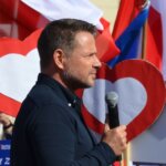 Rafał Trzaskowski przemawiający z mikrofonem podczas spotkania publicznego