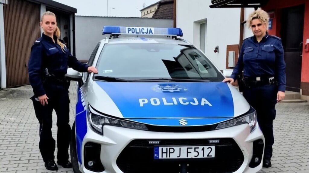 Dwie policjantki w mundurach przy oznakowanym radiowozie