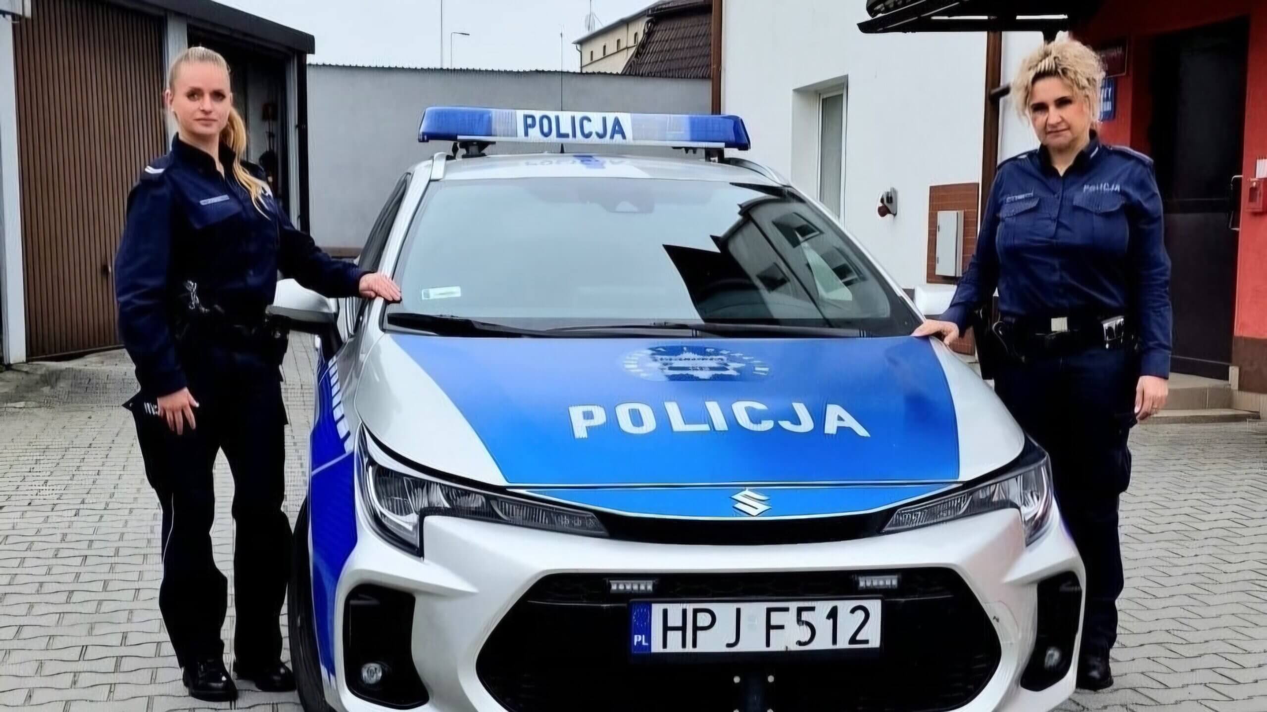 Dwie policjantki w mundurach przy oznakowanym radiowozie