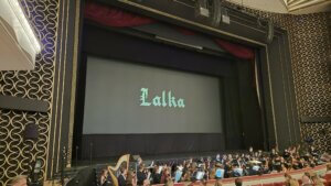 Ekran z tytułem filmu Lalka i orkiestra w Sali Moniuszki Teatru Wielkiego w Warszawie