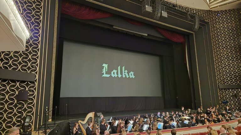 Ekran z tytułem filmu Lalka i orkiestra w Sali Moniuszki Teatru Wielkiego w Warszawie
